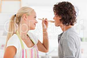 Blonde woman making her fiance tasting her meal