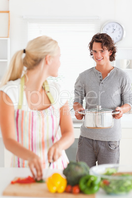 Portrait of a cute man bringing a boiler to her girlfriend