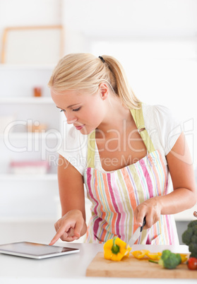 Portrait of a woman using a tablet computer to cook