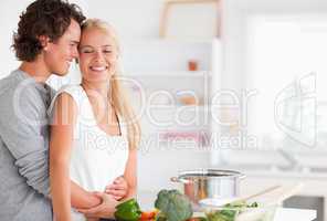 Beautiful couple hugging while cooking