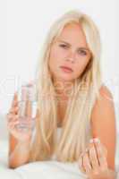 Portrait of a sick woman taking a pill