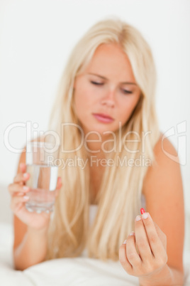 Portrait of an ill woman taking a pill