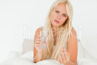 Blonde woman taking a pill