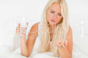 Blonde woman looking at a pill