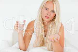 Blonde woman showing a pill