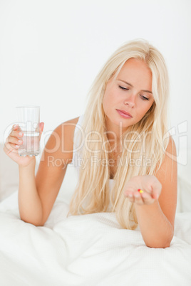 Portrait of a woman looking at a pill