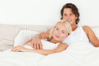 Happy couple lying on a bed