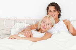 Happy couple lying on a bed