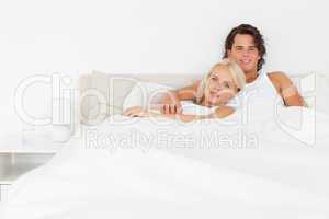 Smiling couple lying on a bed