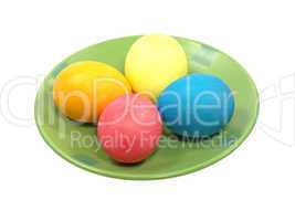 Multicolored eggs on a green plate.