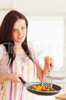 Woman frying vegetables in frying pan
