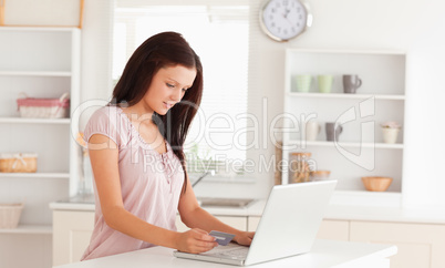 Woman at laptop holding credit card