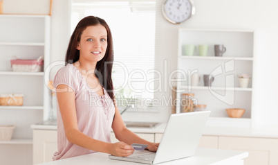 Woman with credit card and laptop looking