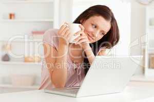 Woman with cup of coffee and laptop