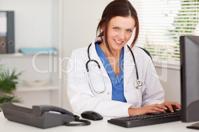 Smiling female doctor typing