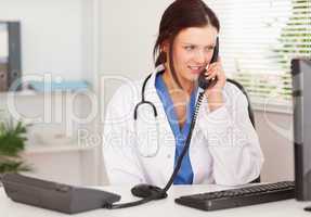 Female doctor telephoning in office