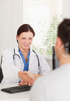 Female doctor hand shaking with a patient