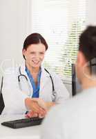 Female doctor hand shaking with a patient