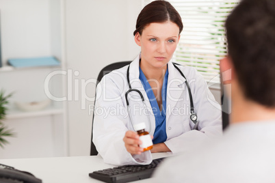 Female doctor giving a patient pills