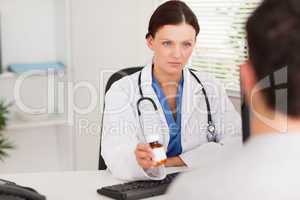 Female doctor giving a patient pills