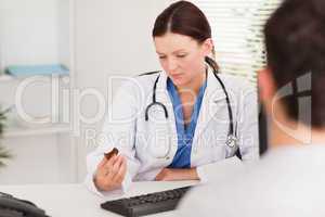 Female doctor looking at pills