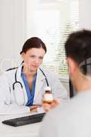 Female doctor looking at patient with pills