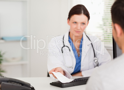 Female doctor giving a patient prescription