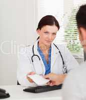 Kind female doctor giving patient prescription