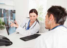 Female doctor showing x-ray to other doctor