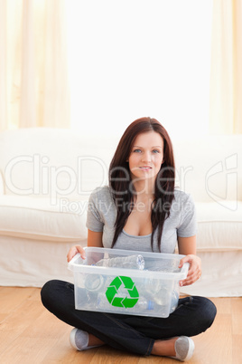 Sitting woman holding recycling bin