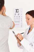 Female optician testing eyes of a man