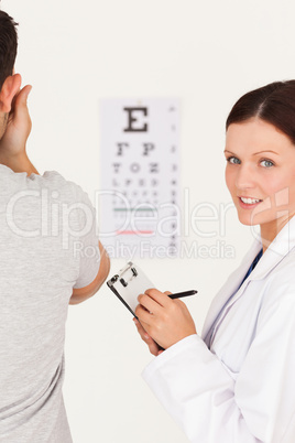 Female optician making notes