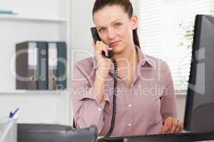 Telephoning businesswoman in office