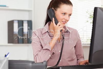 Businesswoman with telephone looking to screen