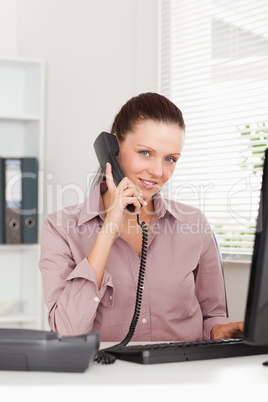 Businesswoman telephoning at workplace