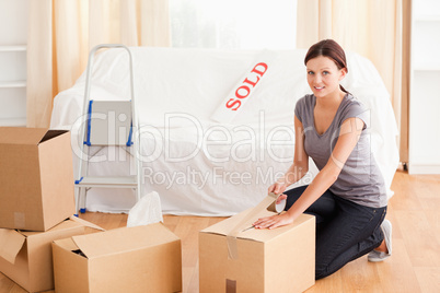 Female preparing cardboard box for transport