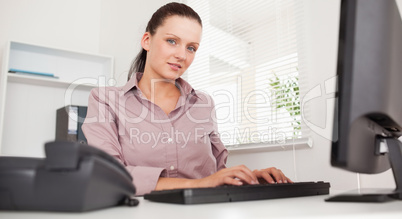 A businesswoman is typing on her keyboard