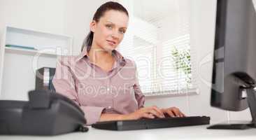 A businesswoman is typing on her keyboard