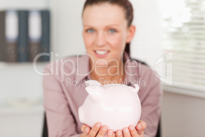 Businesswoman holding piggy bank