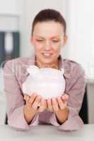 Businesswoman holds piggy bank
