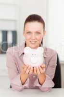 Businesswoman holding piggy bank