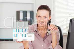 Businesswoman shows keys and model house