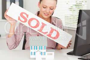 Businesswoman holding a sold sing