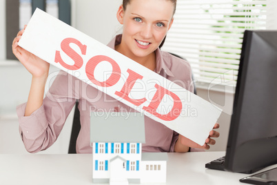 Businesswoman showing sold sign