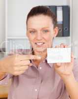 Gorgeous businesswoman pointing at a card