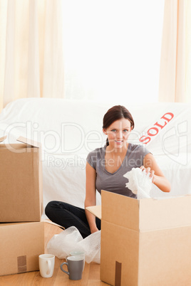 Charming redheaded woman packing her property