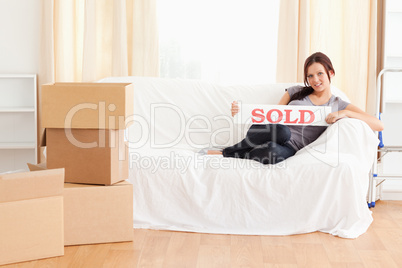 Cute woman holding a sold sign