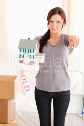Portrait of a woman holding model house and keys