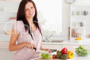 Cute woman cutting vegetables
