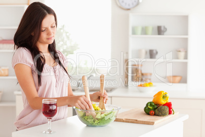 Young woman mixing a salad